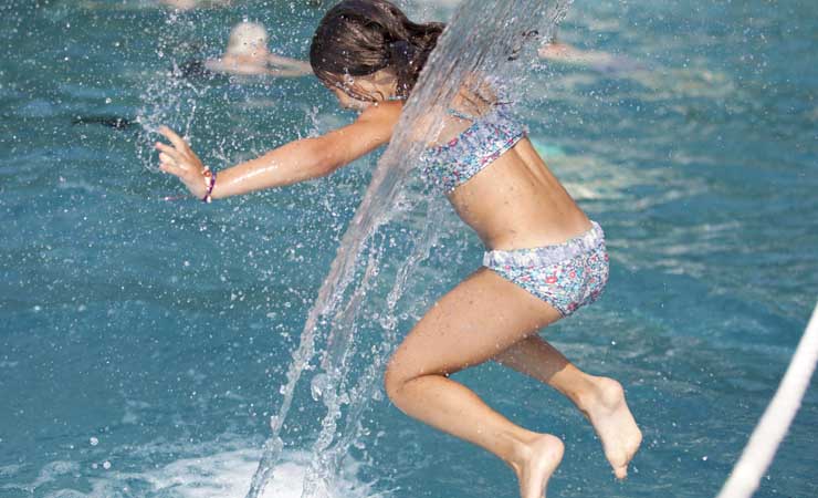 Ein Mädchen im Freibad beim Sprung ins Wasser