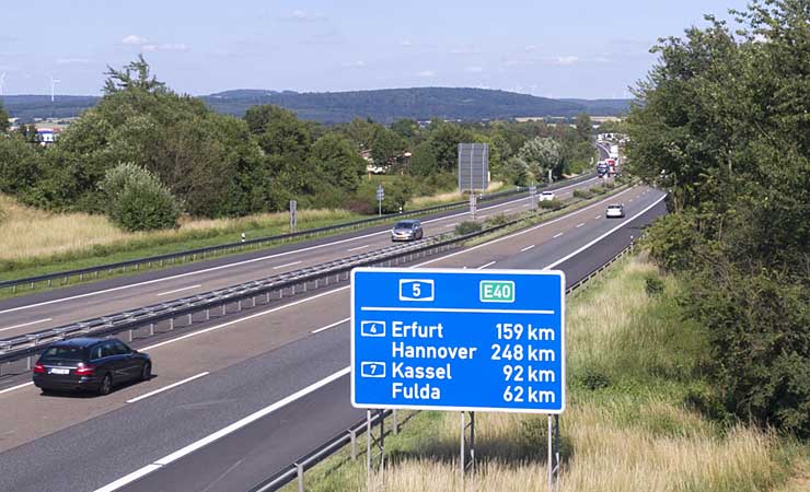 Die A5 mit Autoverkehr, vorne rechts ein Schild mit Entfernungen Erfurt, Hannover, Kassel und Fulda