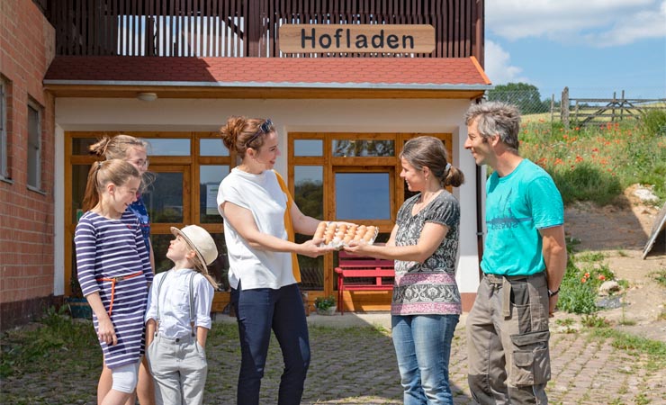 Eine Kundin mit Kindern vorm Hofladen der Familie Lorenzen in Schlitz