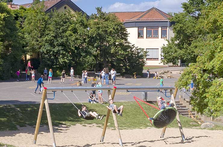 Symbolbild für Schulen: Pausenhof mit spielenden Kindern
